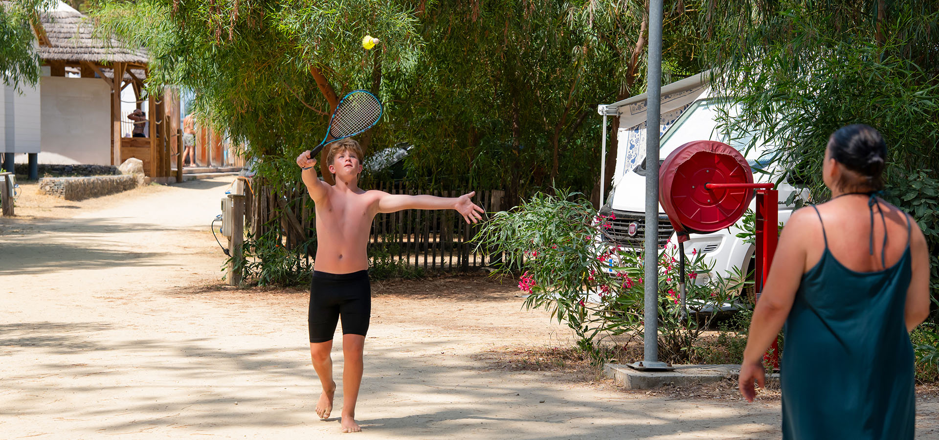 Camping san damiano emplacement confort mere et son fils qui jouent au badmington