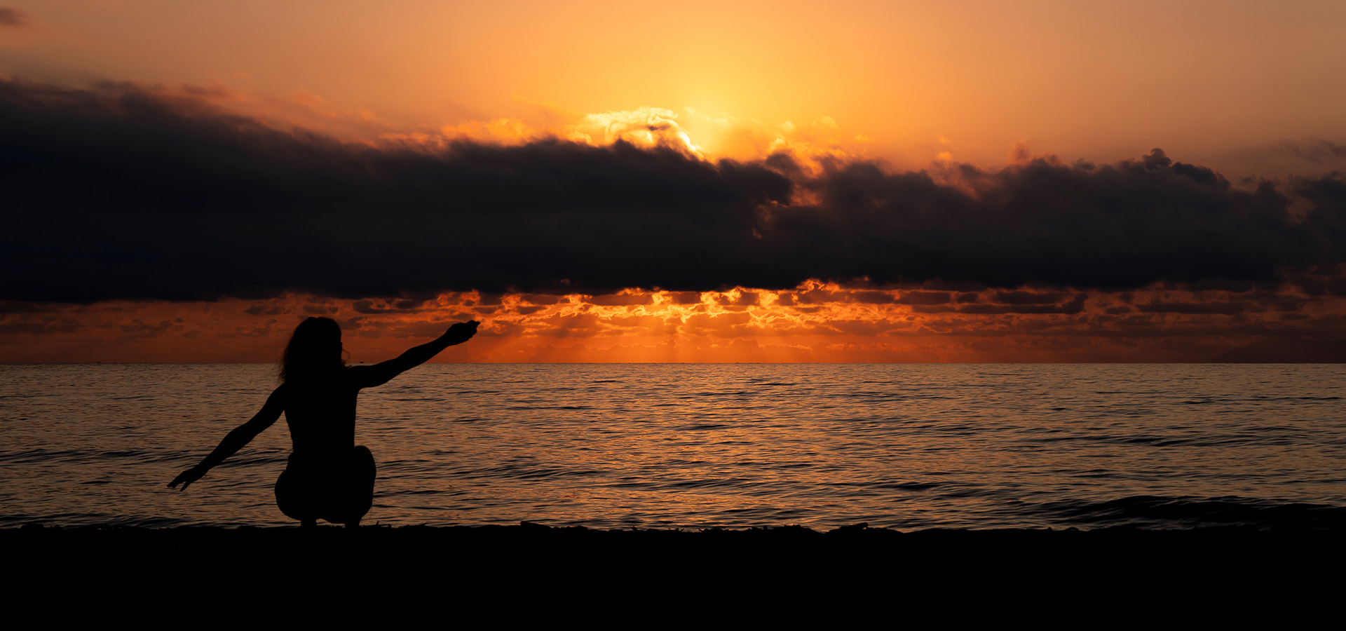 Camping san damiano plage femme qui admire lever de soleil cacher par un nuage